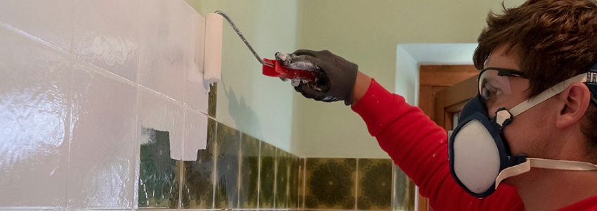 Een persoon is badkamer tegelverf aan het aanbrengen